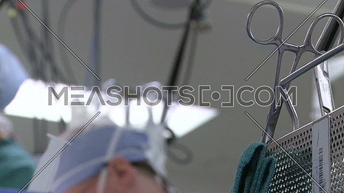 Close shot for Surgical clamp and nurse face in background in operating room