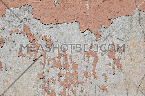 Vintage flakes of old faded pink paint over abandoned grey concrete wall