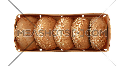 Close up one wooden crate box of fresh brown portobello mushrooms isolated on white background, elevated top view, directly above