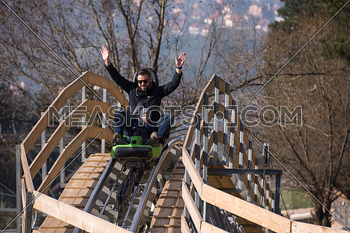 Excited father and son enjoys driving on alpine coaster