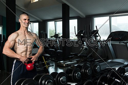 Young Man Working With Kettle Bell In A Gym