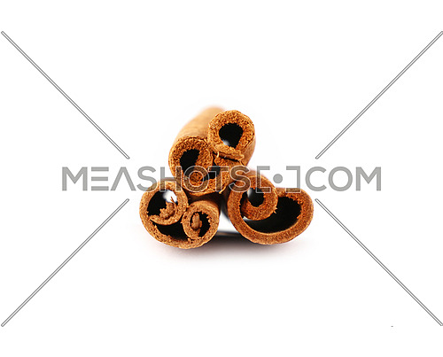 Close up heap of three cinnamon sticks isolated on white background, low angle view