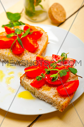 Italian tomato bruschetta with thyme and mint leaves