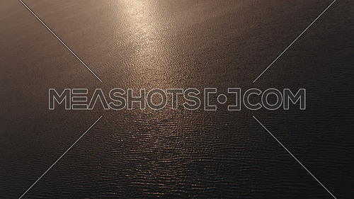 Aerial shot flying over the sea at dusk.