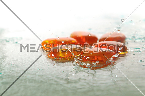 isolated wet zen stones with splashing  water drops  representing concept of natural balance and perfect harmony
