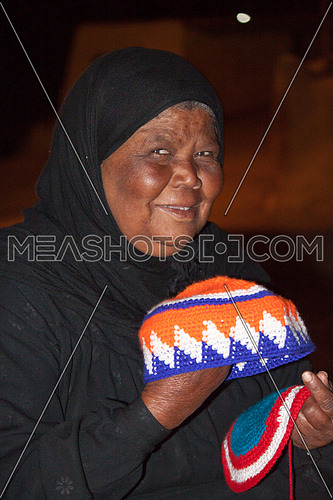Old Woman holding hand made nubiean hats