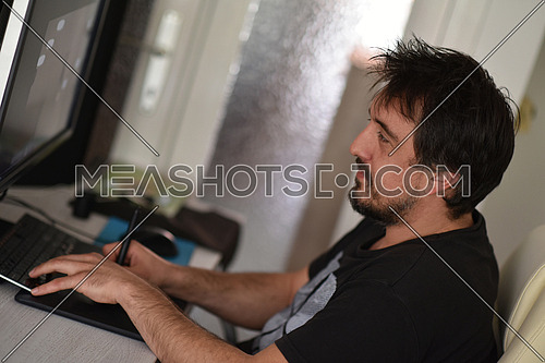graphic designer working on a digital tablet and a computer