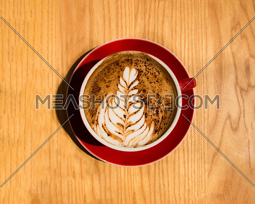 a red cup of cappuccino in a modern coffee shop