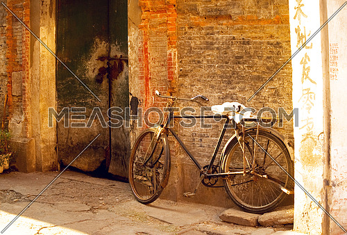 shanghai old bicycle over a brick walland old door