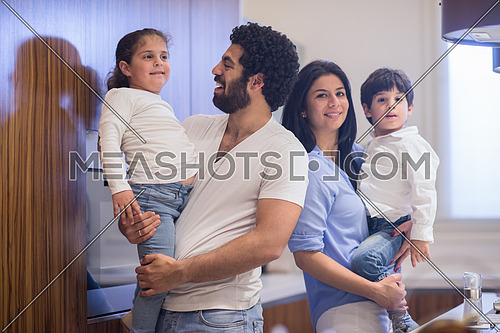 young middle east father and mother with children spend cheerful time in the kitchen
