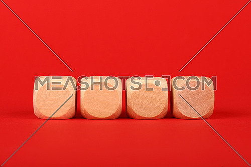 Close up four blank empty wooden cube signs over red background with copy space, low angle front view