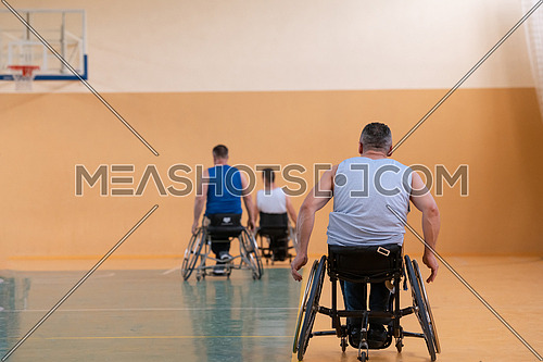 photo of wheelchairs and handicapped war veterans playing basketball on the court. High quality photo