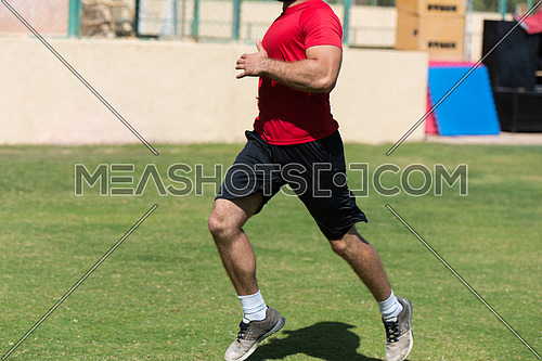 young middle eastern man athlete training running on the pitch on a sunny day