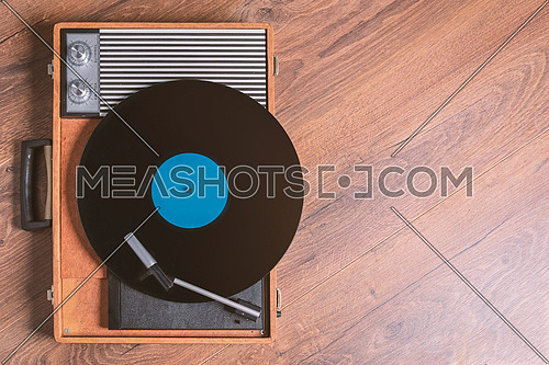 Vintage Gramophone with a vinyl record on wooden table, top view and copy space,photo.
