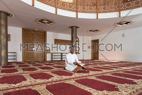 Black African Muslim Man Making Traditional Prayer To God While Wearing A Traditional Cap Dishdasha