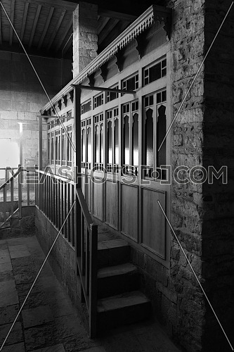 Black and white weathered porch of aged ornamental building at dark night