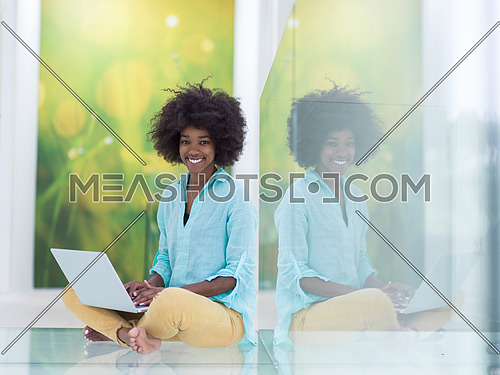 beautiful young african american women using laptop computer on the floor at home