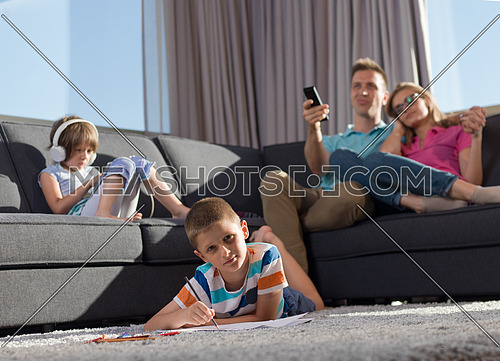 Happy Young Family Playing Together at home using a tablet and a children's drawing set