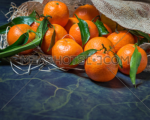 Fresh mandarins stacked on jute sack