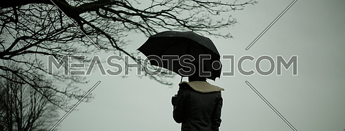 A person holding an umbrella during a rainy day