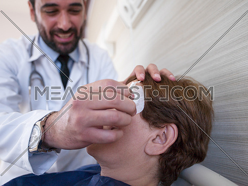 doctor and happy patient at eye clinic, doctor checking patients eye in optometry clinic