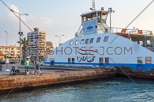 Port Fuad, Egypt - November 10, 2018: Local citizens of Port Fuad district fishing beside Port Said ferry boat at Suez Canal