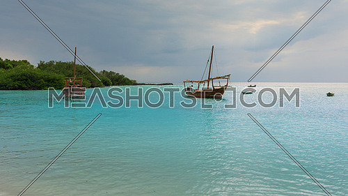 Anchored wooden dhow boats on the amazing turquoise water in the Indian ocean  Zanzibar, Tanzania.