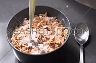 Pouring cereal flakes and milk