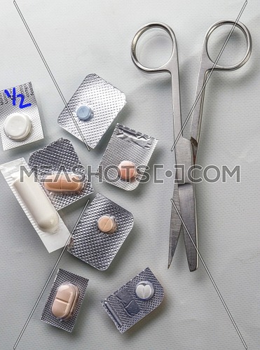 Different types of medications with scissors in a hospital, conceptual image