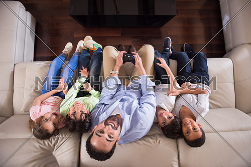 middle eastern man enjoys playing video games with the kids on the sofa