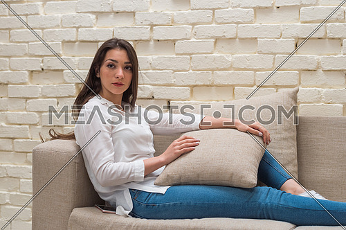 A young woman sits alone at home