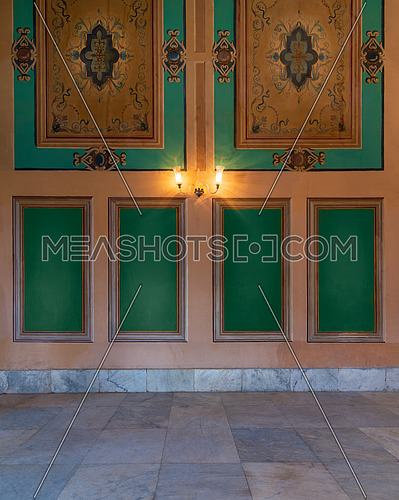 Beautiful elegant carved green frames on orange wall with ornate border and white marble tiled floor, in abandoned old building