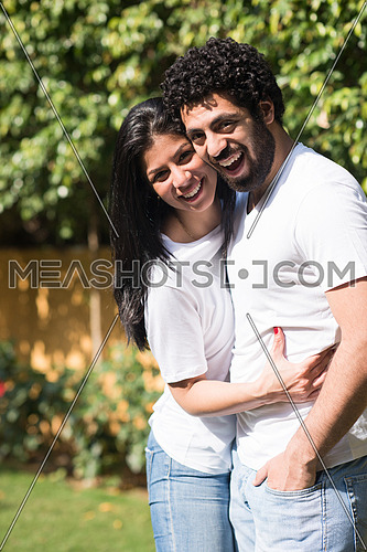 Young Middle Eastern couple enjoying the beautiful summer day in the garden with a smile and happiness