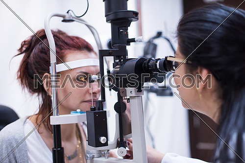Professional middle eastern oculist is checking human vision with equipment in the modern clinic