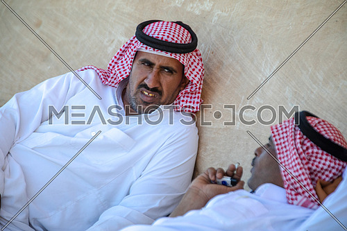 med-shot for Two bediuon males wearing traditional clothing and having rest and talking in Sinai at day.