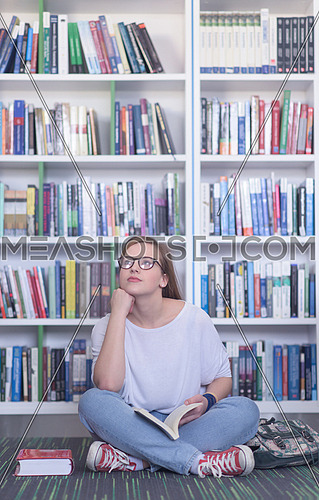 smart looking famale student girl  in collage school library reading book
