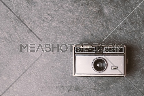 Retro classic 35mm photo camera on gray stone Background