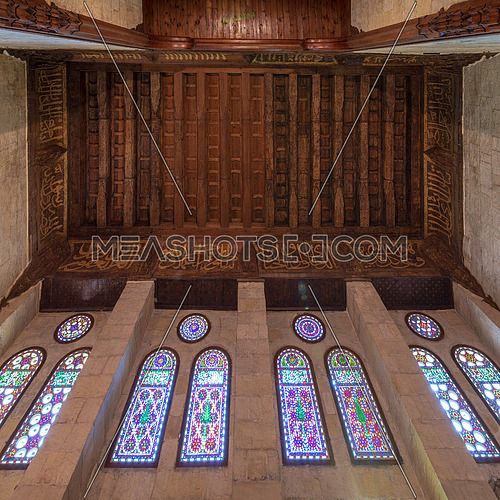 Wooden ornate ceiling with floral pattern decorations and colorful stained glass windows at Sultan al Ghuri Mausoleum, Cairo, Egypt