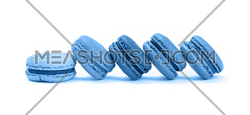 Close up row of several fresh traditional French macaroon pastry cookies (macarons, macaroni) isolated on white background, low angle view, blue toned