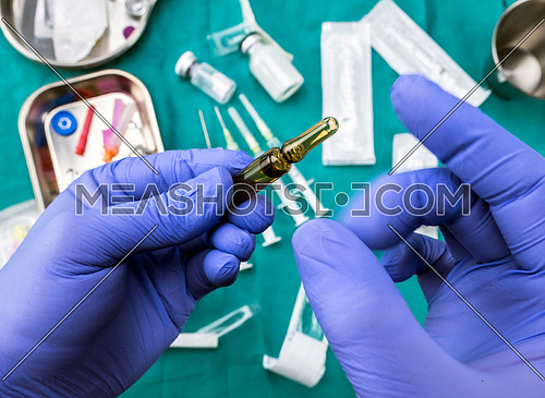 Nurse preparing medication in a hospital, opening medicine ampoule, conceptual image, horizontal composition