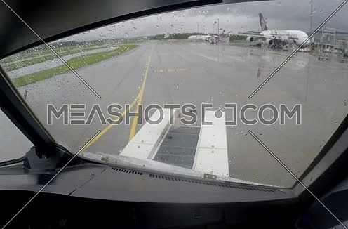 inside cockpit shot for plane taxiing at airport at rainy day