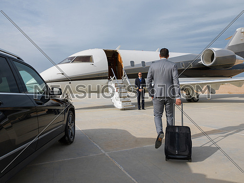young successful middle eastern businessman with a suitcase walking in front of private airplane