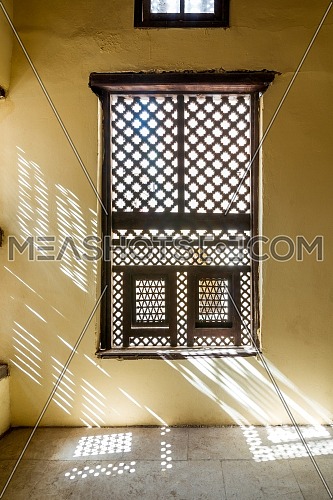 Single interleaved grunge wooden ornate windows - Mashrabiya - in stone wall at abandoned building