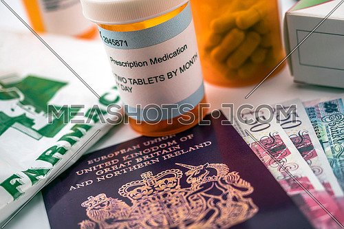 British passport along with several bottles of medicines, concept of medical increase in the crisis of the brexit, conceptual image, horizontal composition