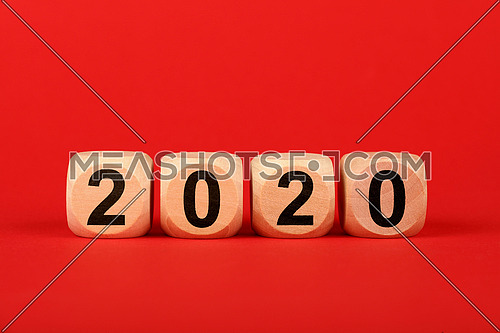 Close up wooden cube signs with 2020 word over red background with copy space, elevated top view, directly above
