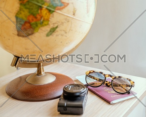 Concept travel, globe, photo camera,sun glasses,ticket airplane and passport on a wooden table. Idea, photo tourism, adventure, travel around the world