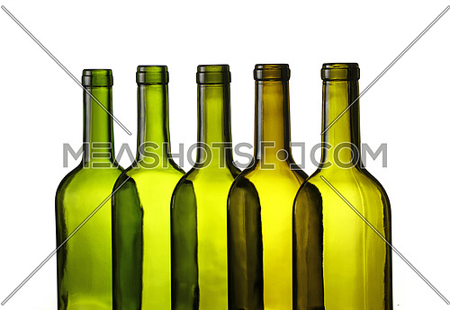 Close up group of five empty washed green glass wine bottles in a row isolated on white background, low angle side view