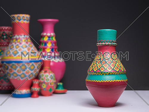 Decorated colorful pottery vase on background of blurred colorfu