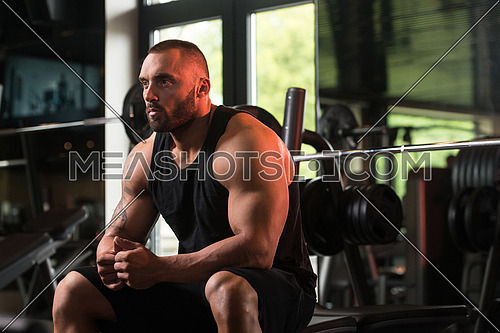 Big Bodybuilder Resting At The Bench In A Gym