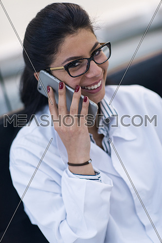 young middle eastern doctor talking on the phone in a large modern clinic